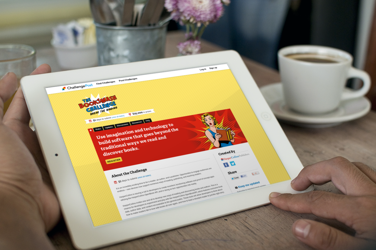 Two hands hold an iPad displaying a hackathon homepage called 'The Booksmash Challenge'. The subtitle is 'Use imagination and technology to build software that goes beyond the traditional ways we read and discover books'.